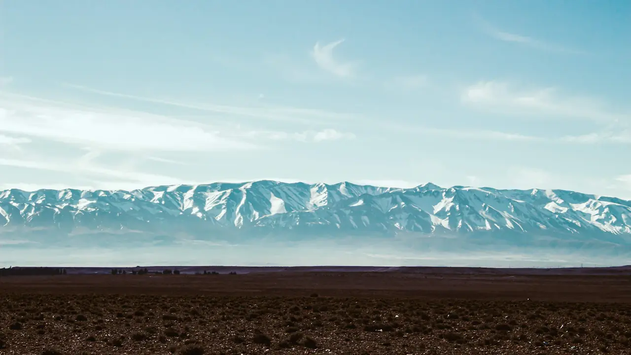 Snow-capped Atlas Mountains rising above Morocco’s rocky foothills